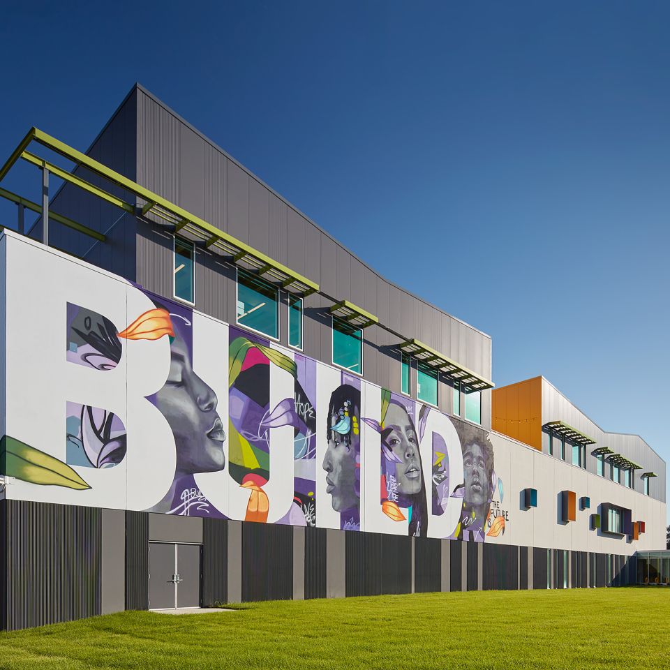 New BUILD Chicago campus, which opened in 2023. Building has mural on the side that says "BUILD" with images of the faces of youth between the letters.