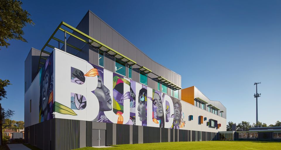 New BUILD Chicago campus, which opened in 2023. Building has mural on the side that says "BUILD" with images of the faces of youth between the letters.